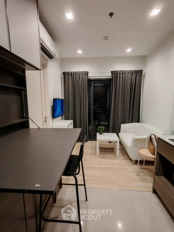 Modern living room with sleek furniture and balcony view in a stylish apartment.