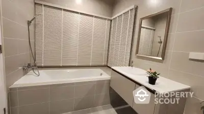 Modern bathroom with bathtub and sleek vanity in neutral tones