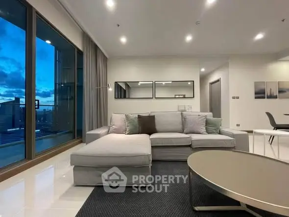 Modern living room with elegant decor and stunning city view from large windows.