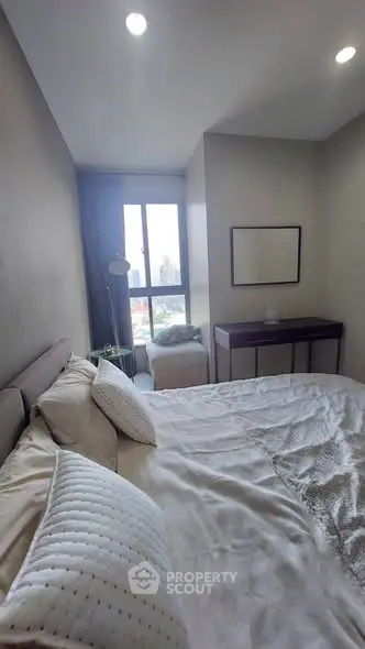 Cozy bedroom with city view, featuring a comfortable bed and modern decor, perfect for urban living.