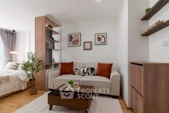 Modern living room with cozy sofa and stylish decor in open-plan apartment.