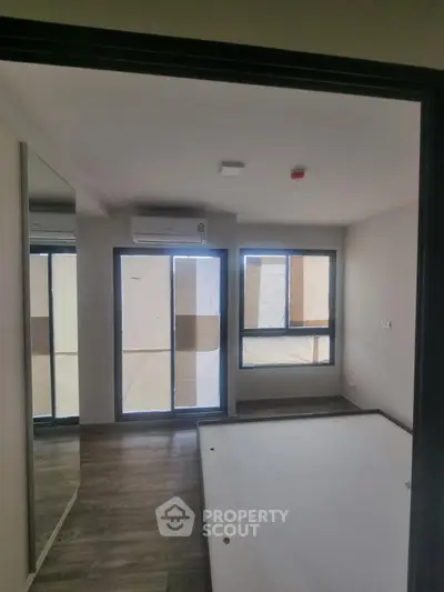 Modern bedroom with large windows and air conditioning in a new apartment