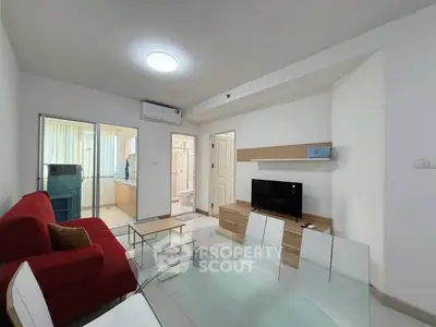 Modern living room with red sofa, TV, and dining area in open layout.