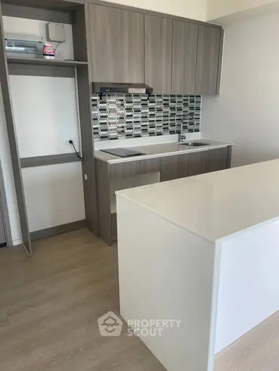 Modern kitchen with sleek cabinetry and stylish backsplash in a contemporary apartment.