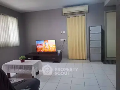 Cozy living room with air conditioning and modern TV setup, perfect for relaxation.