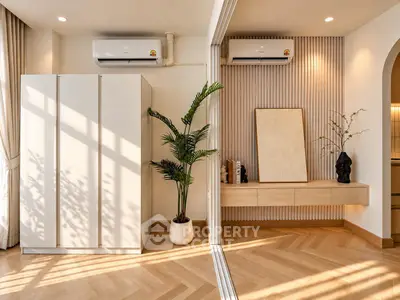 Modern living room with stylish decor and natural light, featuring air conditioning and elegant wood flooring.