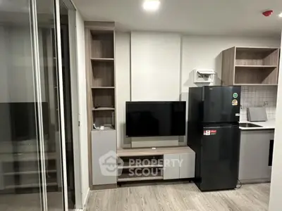 Modern apartment living room with sleek TV setup and contemporary kitchen