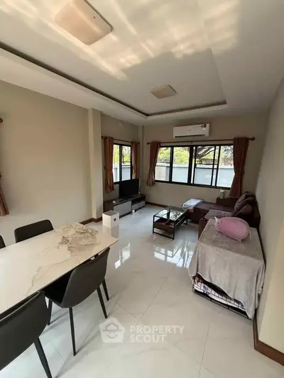 Spacious living room with modern decor and large windows offering natural light.