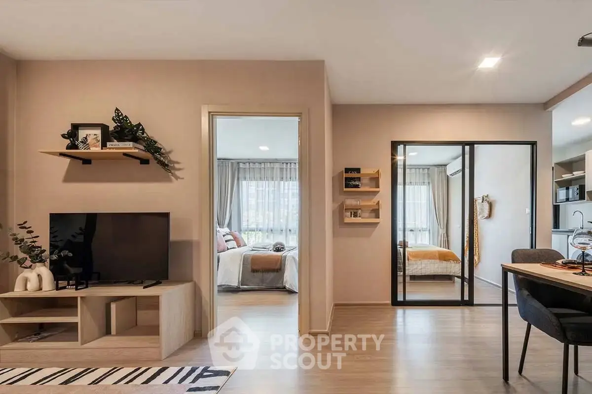 Modern open-plan living room with stylish decor and view into bedroom.