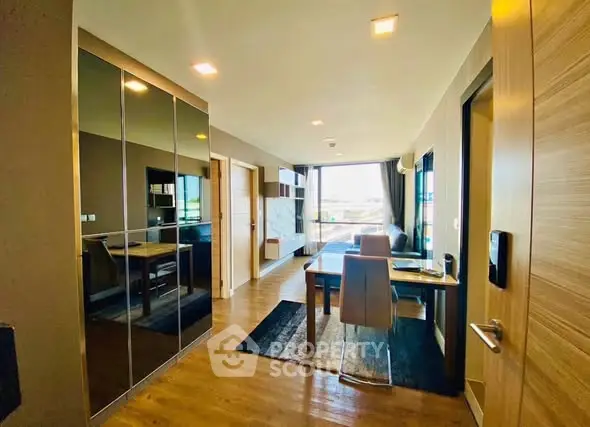 Modern open-plan living and dining area with sleek furnishings and large windows.