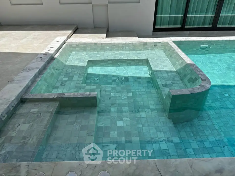 Luxurious modern swimming pool with elegant marble tiles and sleek design.