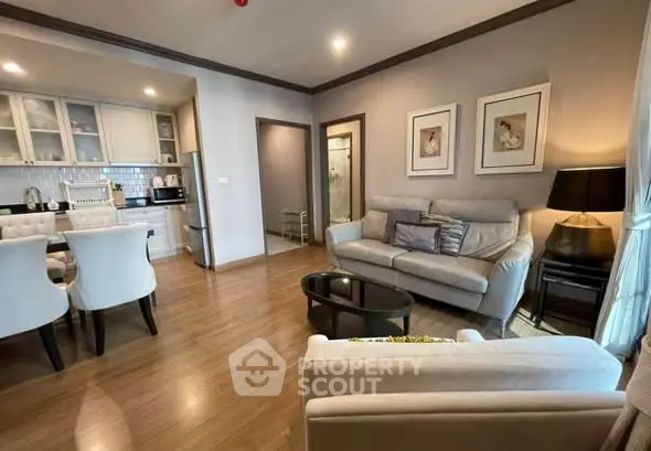 Modern living room with open kitchen, elegant decor, and cozy seating area.