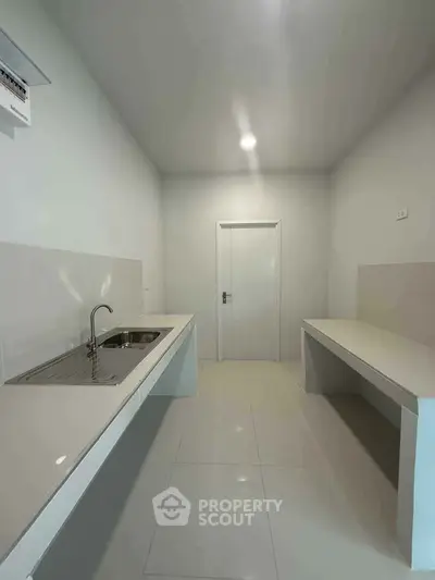 Minimalist kitchen with sleek countertops and modern sink