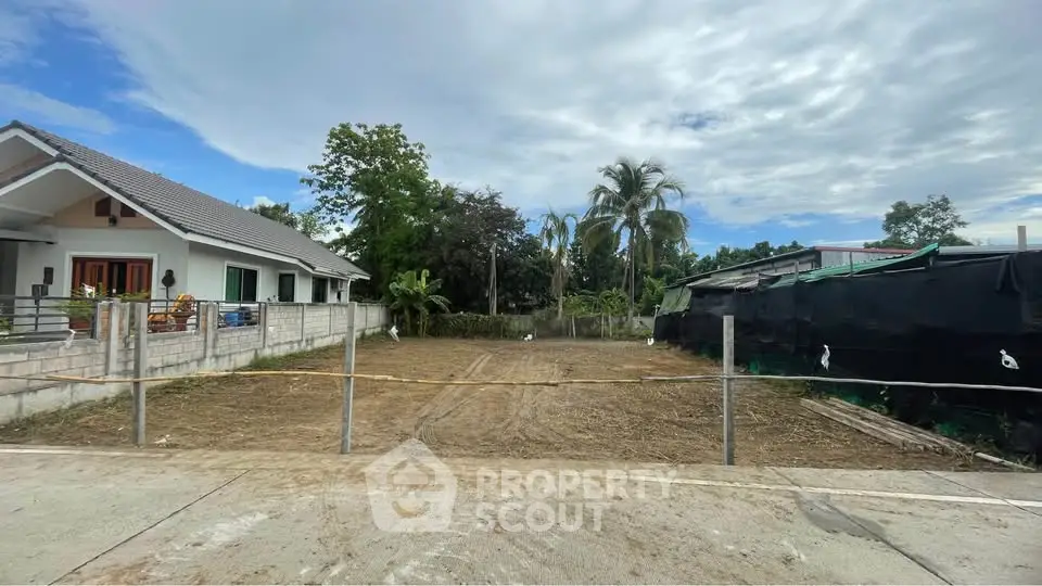 Vacant land plot with potential for development in a serene neighborhood, surrounded by lush greenery and modern homes.