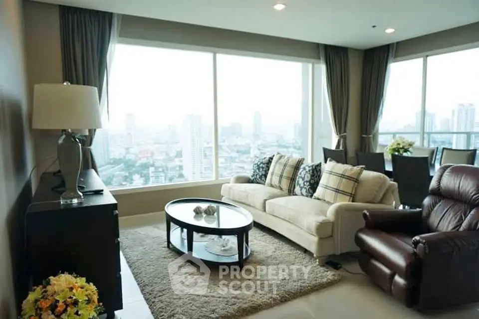 Luxurious living room with panoramic city view, elegant furnishings, and abundant natural light.