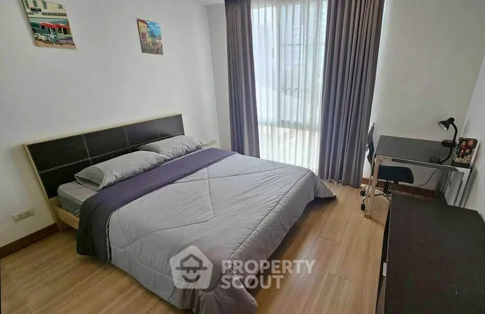 Modern bedroom with cozy bed, study desk, and large window with curtains.
