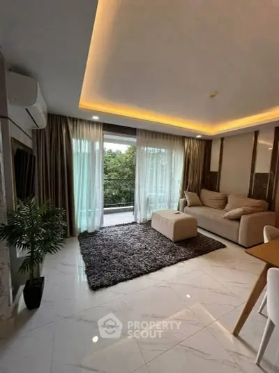 Elegant living room with modern decor and large windows opening to a balcony.