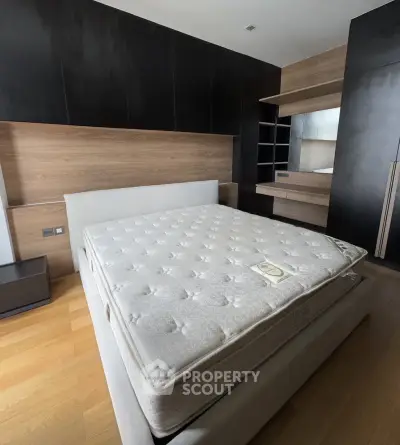 Spacious modern bedroom with sleek wooden accents and comfortable bed