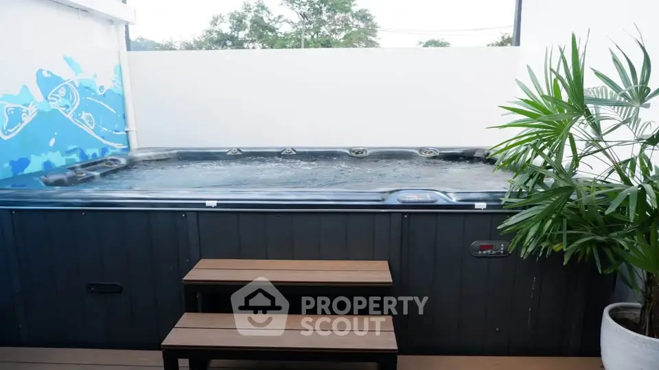 Luxurious outdoor jacuzzi with modern design and privacy wall, perfect for relaxation and entertainment.