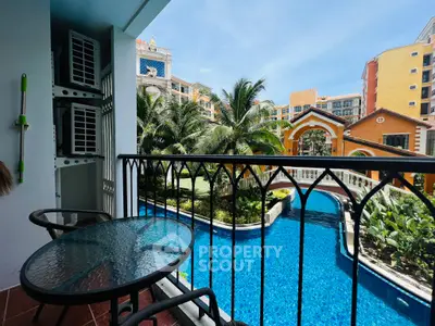 Charming balcony overlooking a luxurious pool and lush garden in a vibrant residential complex.