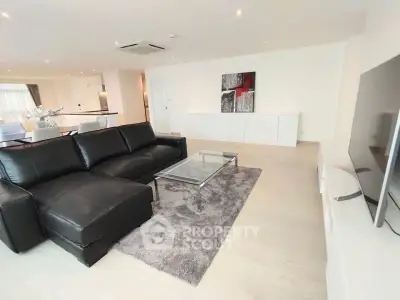 Spacious modern living room with sleek black leather sofa and stylish decor