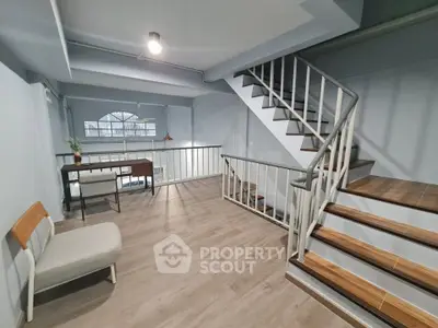 Modern duplex interior with stylish staircase and cozy seating area, perfect for urban living.