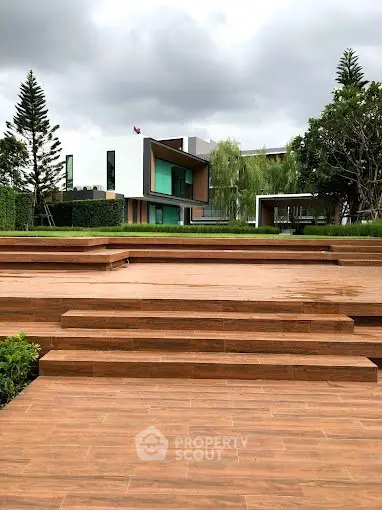 Modern architectural home with lush garden and spacious wooden terrace.