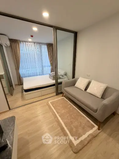 Modern studio apartment with cozy living area and glass partitioned bedroom.