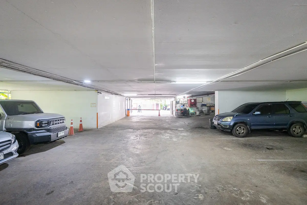 Spacious underground parking area with multiple vehicles and ample lighting.