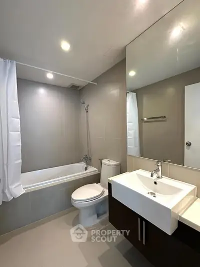 Modern bathroom with sleek fixtures and a bathtub in a contemporary apartment.
