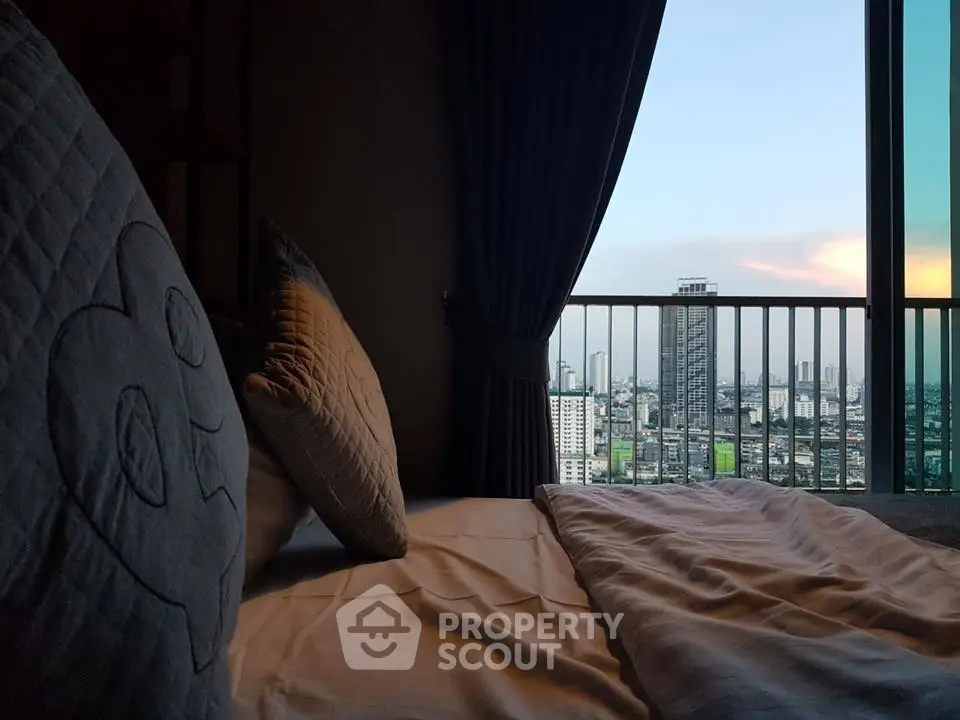 Luxurious bedroom with stunning city view from high-rise apartment balcony.