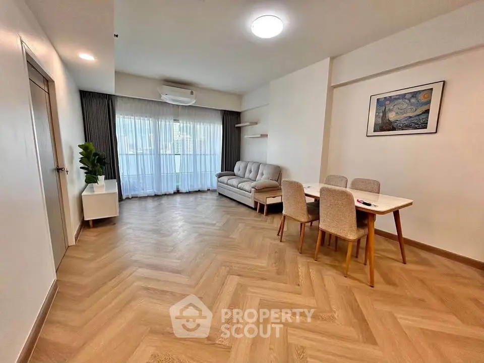 Spacious modern living room with elegant herringbone flooring and stylish furniture, perfect for relaxation.
