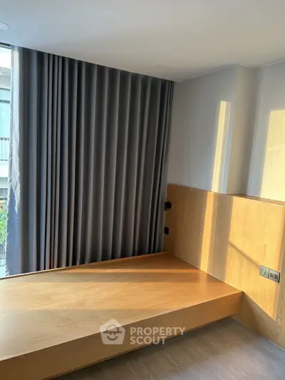 Modern minimalist bedroom with wooden platform bed and floor-to-ceiling curtains