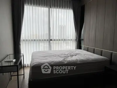 Modern bedroom with large window and elegant furnishings