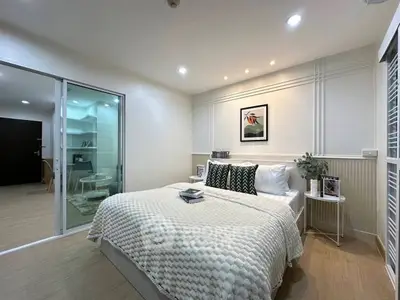 Modern bedroom with cozy decor and glass sliding door to living area