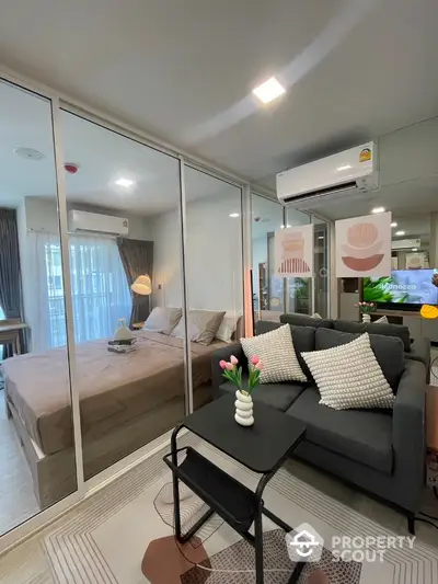 Modern studio apartment with glass partition, cozy living area, and stylish decor