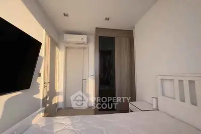 Modern bedroom with sleek wardrobe and wall-mounted TV, perfect for urban living.