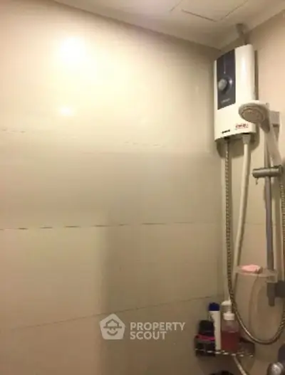 Modern bathroom with shower and water heater in sleek design.