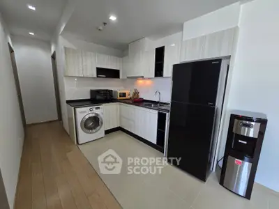 Modern kitchen with sleek appliances and washing machine in a stylish apartment.