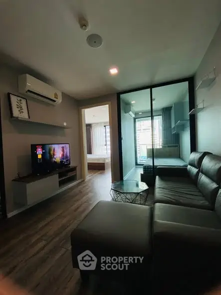 Modern living room with sleek furniture and glass partition in stylish apartment.