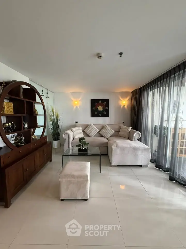 Elegant living room with modern furniture and large windows offering natural light.