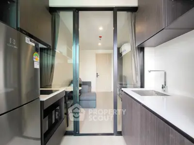 Modern kitchen with sleek cabinetry and stainless steel appliances in a stylish apartment.