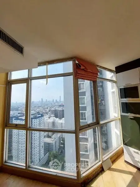 Spacious corner unit with floor-to-ceiling windows offering a stunning city view, perfect for urban living.