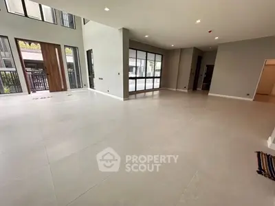 Spacious modern living room with large windows and sleek tile flooring