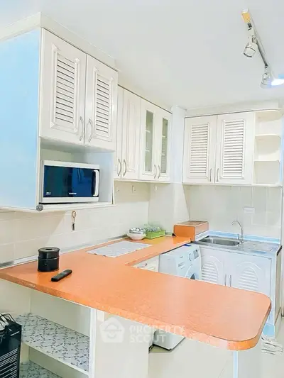 Charming kitchen with modern appliances and cozy breakfast bar in a bright, inviting space.