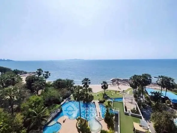 Stunning beachfront view with pool and lush greenery, perfect for luxury living.