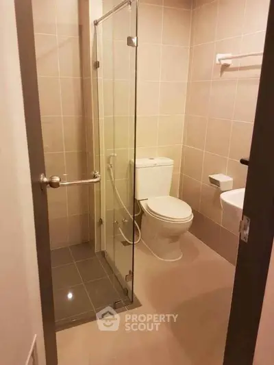 Modern bathroom with glass shower enclosure and sleek tile design.