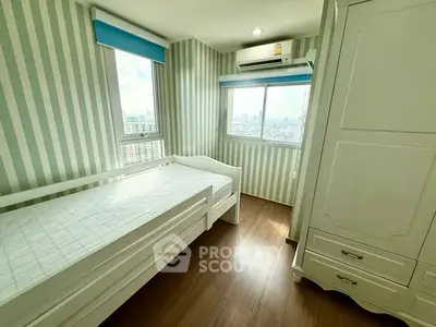 Bright bedroom with striped walls and city view, featuring a single bed and wardrobe.