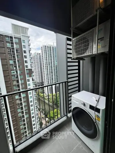High-rise balcony with washer and cityscape view, perfect for urban living.