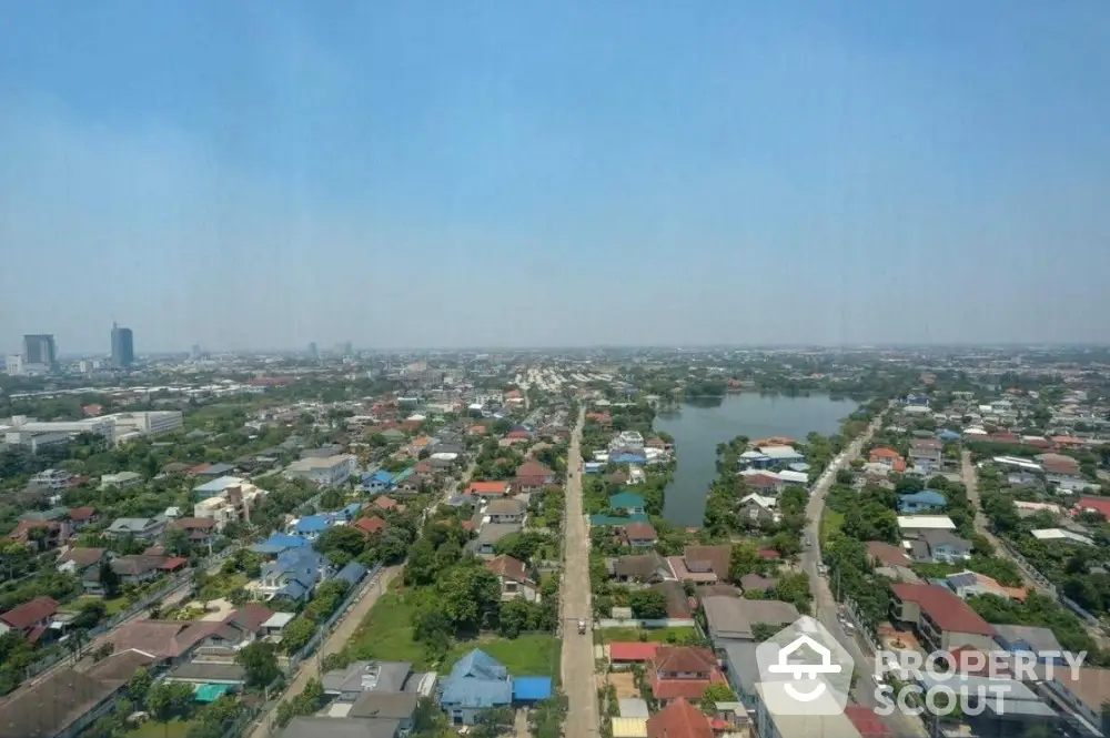 Stunning aerial view of a sprawling residential neighborhood with lush greenery and a serene lake.